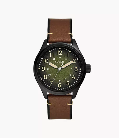 Un homme avec une montre d’aventurier à cadran vert et lunette noire et un bracelet de cuir noir à l’autre poignet.
